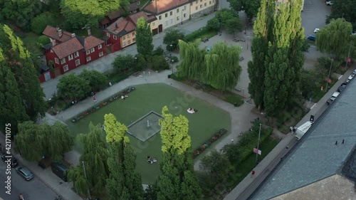 Stockholm, Sweden. Panoramic aerial flying drone view of the square, Nytorget, and Sofiakyrkan, SoFo, Vitabergsparken, Södermalm. Summer evening people hanging out.