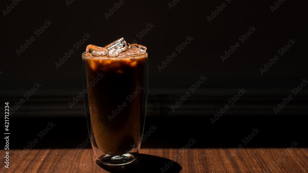 Close-up glass of iced coffee with milk on the table