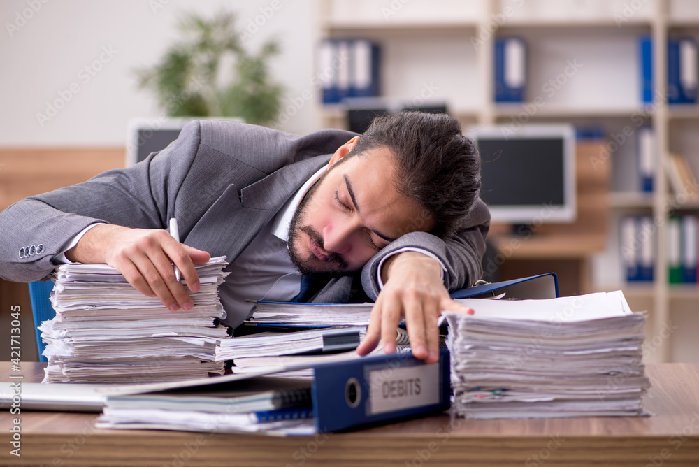 Young businessman employee unhappy with excessive work in the of Young businessman employee unhappy with excessive work in the of