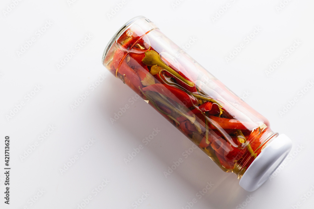 canned chili peppers in a jar on a white background, place for text canned chili peppers in a jar on a white background, place for text