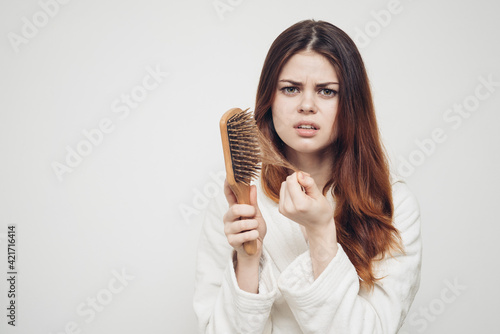 hair loss health problems woman with a comb in her hand on a light background