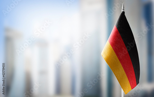 A small flag of Germany on the background of a blurred background