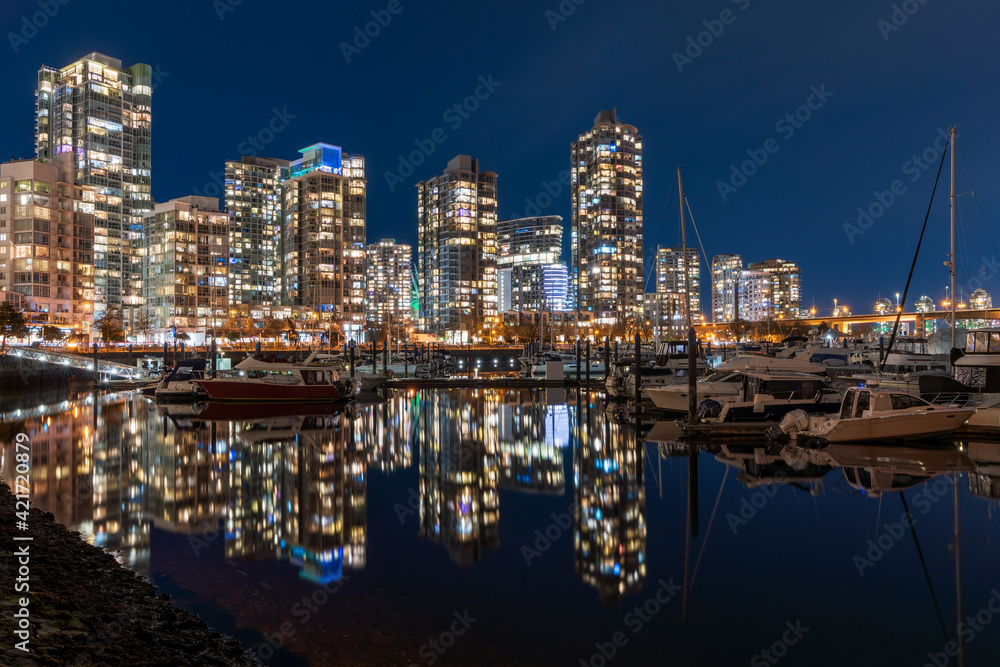 View of Vancouver downtown marina at night. Beautiful buildings skyline reflection on the water. Yaletown Dock. British Columbia, Canada.