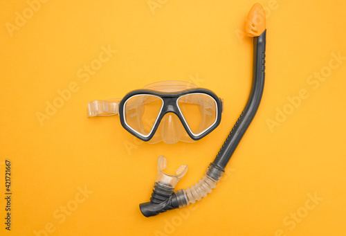 Gray snorkel mask on yellow summer background. The concept of vacation at sea, travel. minimalistic photo of a dive mask and snorkel with a central composition.Flat lay, top view. copy space for text
