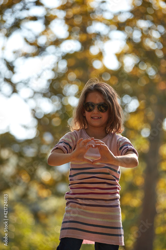 Child girl enjoying outdoors nature in the park.