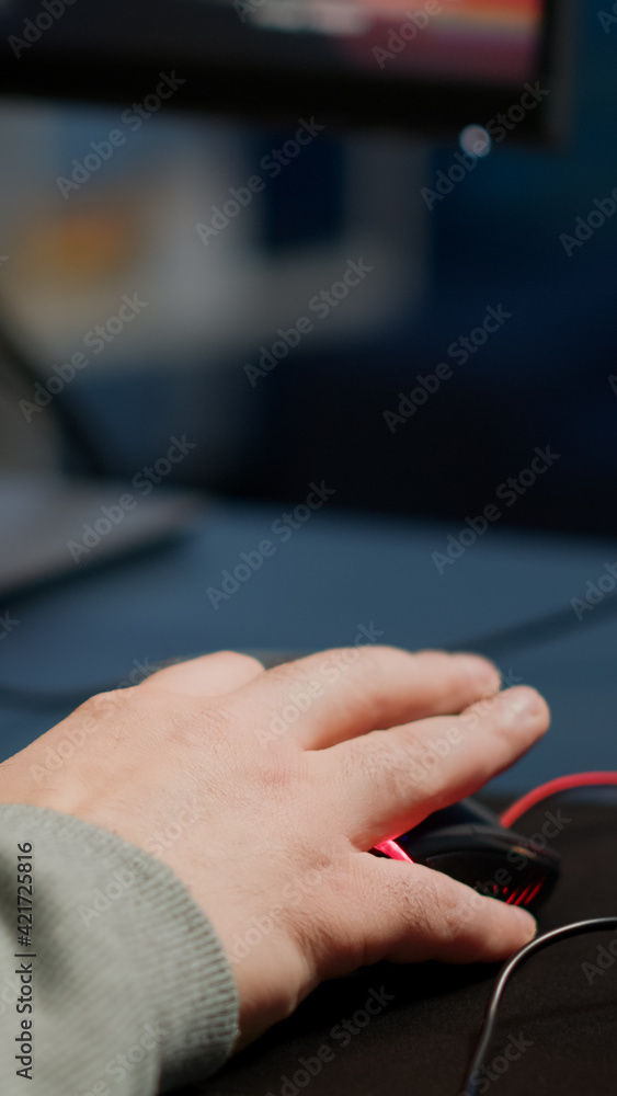 Close-up of man hands gamer playing video game using RGB keyboard during virtual championship in cyberspace. Online streaming cyber performing on powerful personal computer during gaming tournament