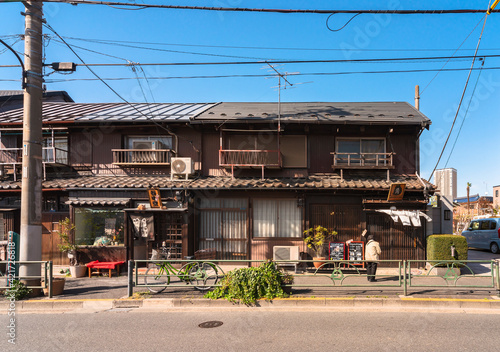 Traditional Showa era Japanese wooden houses rehabilitated into old-Fashioned retro shops in the quiet neighborhood of Yanesen called the cat district. photo
