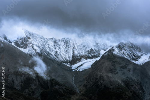 Snow-capped mountain in cloudy sky © Bob