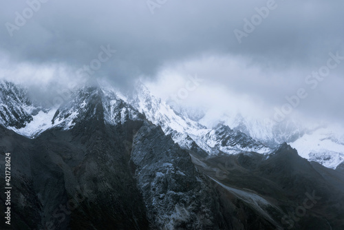 Snow-capped mountain in cloudy sky