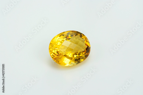 Natural yellow brazilian citrine quartz oval checker faceted gemstone. Unheated, clean, transparent, sparkling, shiny on white backgound. Semiprecious gemstone setting for big solitaire rings.