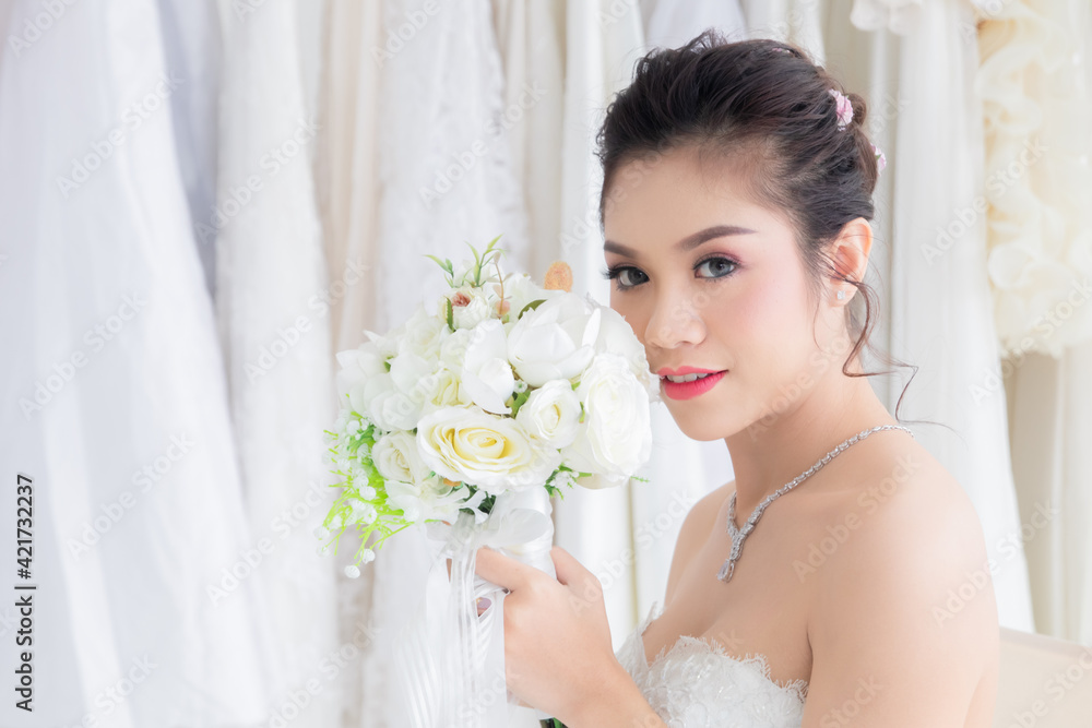 Naklejka premium Asian women seeking foreigner dating concept, beautiful Asian woman in bridal dress hold colorful flowers bouquet close eyes dream to perfect man or rich to create passion relationship or family