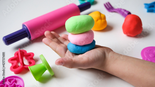 Children's hands play with plastic multi-colored mass. Modeling and development of fine motor skills. photo