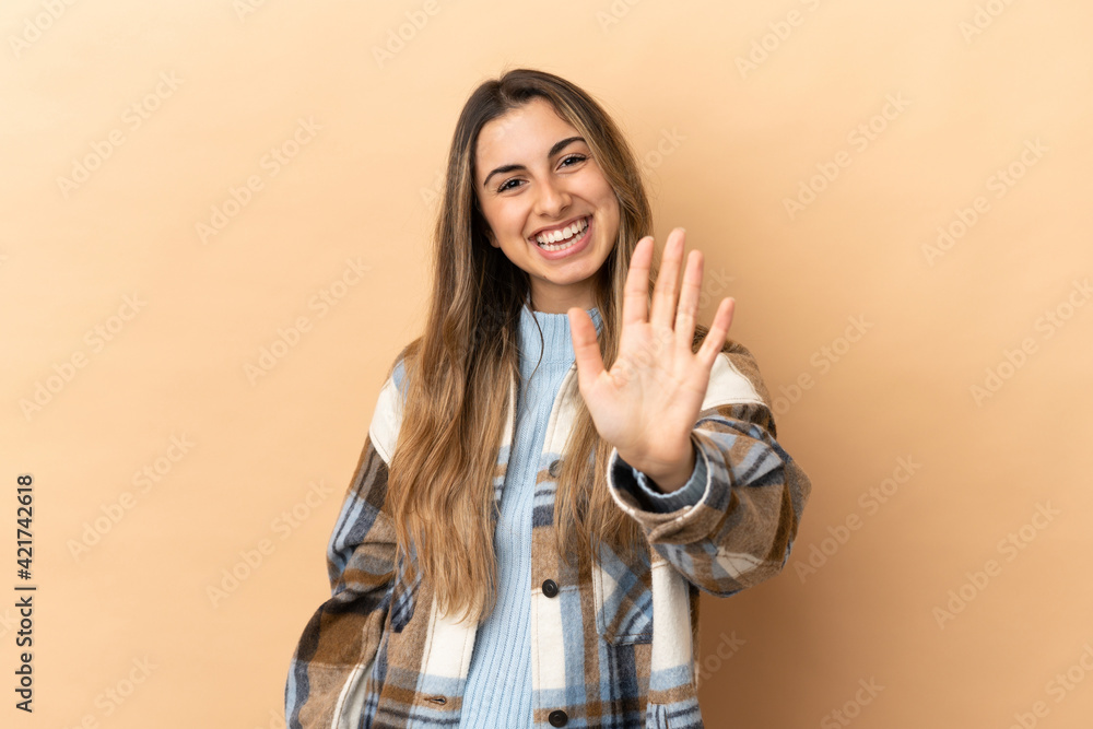 Young caucasian woman isolated on beige background counting five with fingers Young caucasian woman isolated on beige background counting five with fingers