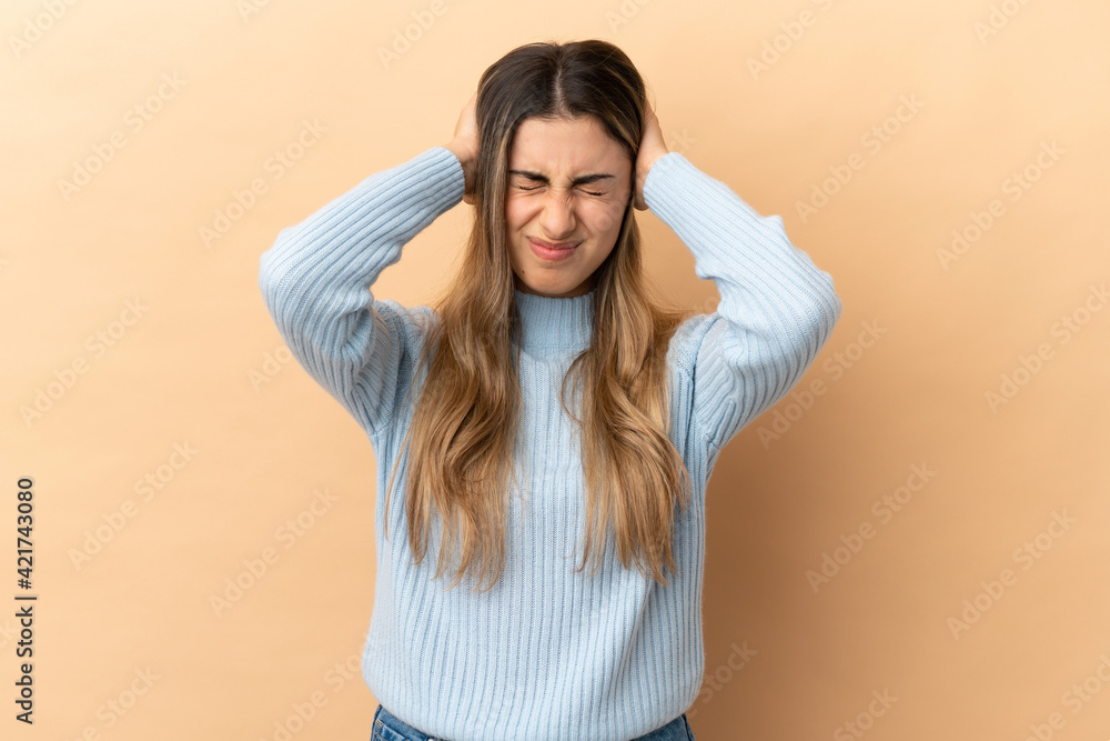 Young caucasian woman isolated on beige background frustrated and covering ears Young caucasian woman isolated on beige background frustrated and covering ears