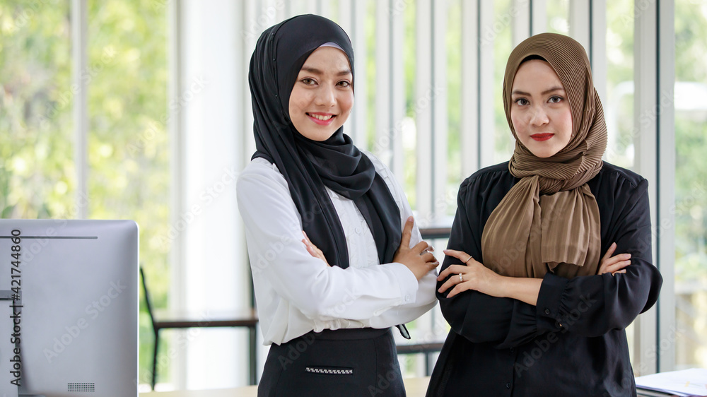 Smiling Muslim female colleagues in modern office Smiling Muslim female colleagues in modern office