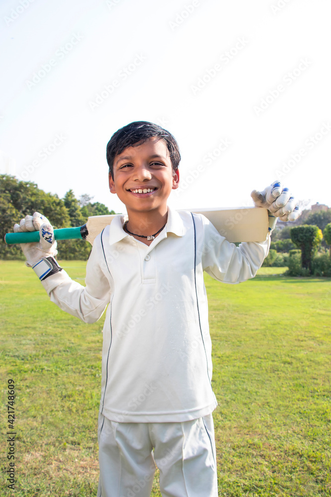 Boy in cricket uniform holding a cricket bat Boy in cricket uniform holding a cricket bat