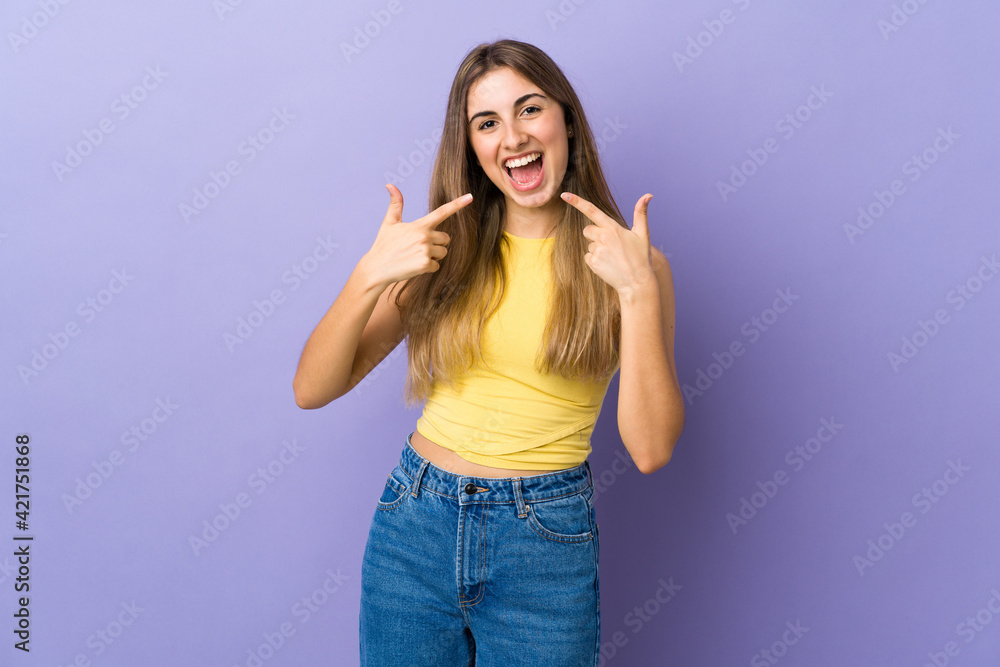 Young woman over isolated purple background giving a thumbs up gesture