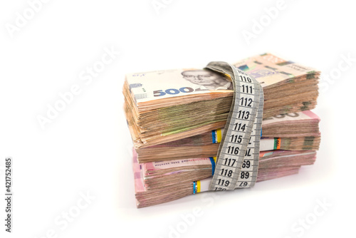 hryvnia tied with a measuring tape on a white background.