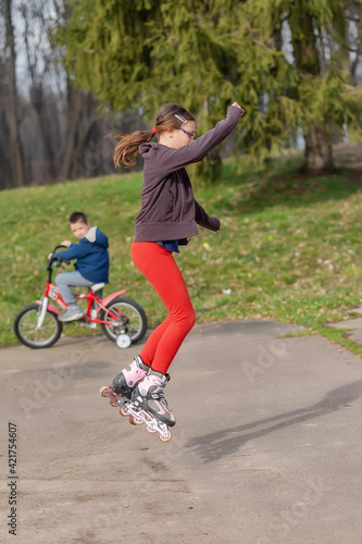 Wallpaper Mural A girl with glasses rides roller skates. Seasonal outdoors children activity sport. The girl jumps with roller skates Torontodigital.ca