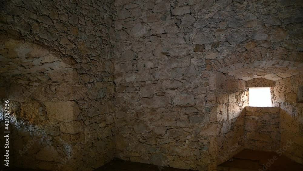 Interior view of ancient tower in castle Kamen, Slovenia. Wooden floor and old stone thick walls. Inside of middle age fortified watchtower. Artificial light. Right pan, wide angle Interior view of ancient tower in castle Kamen, Slovenia. Wooden floor and old stone thick walls. Inside of middle age fortified watchtower. Artificial light. Right pan, wide angle