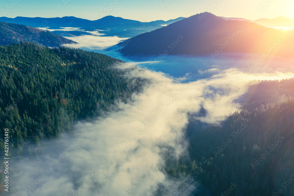 Fantastic view of the tops of the mountain ridge above the clouds at sunrise Fantastic view of the tops of the mountain ridge above the clouds at sunrise