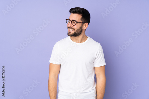 Caucasian handsome man over isolated background looking to the side and smiling