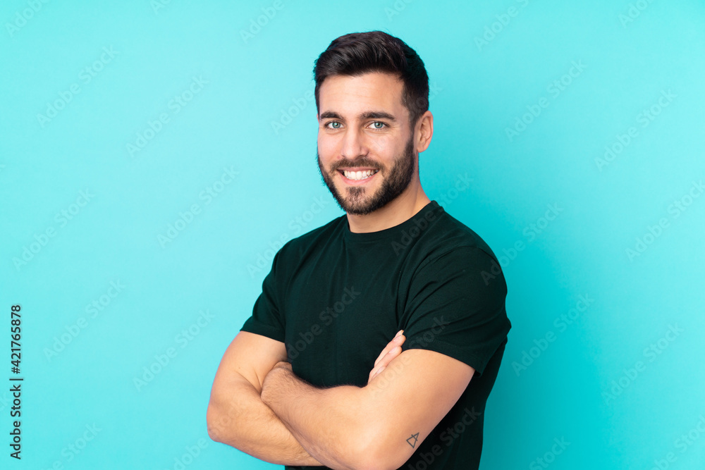 Caucasian handsome man isolated on blue background with arms crossed and looking forward Caucasian handsome man isolated on blue background with arms crossed and looking forward