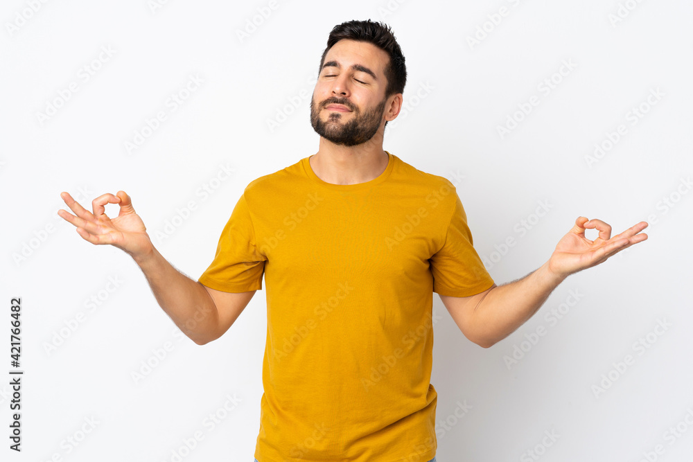 Young handsome man with beard isolated on white background in zen pose Young handsome man with beard isolated on white background in zen pose