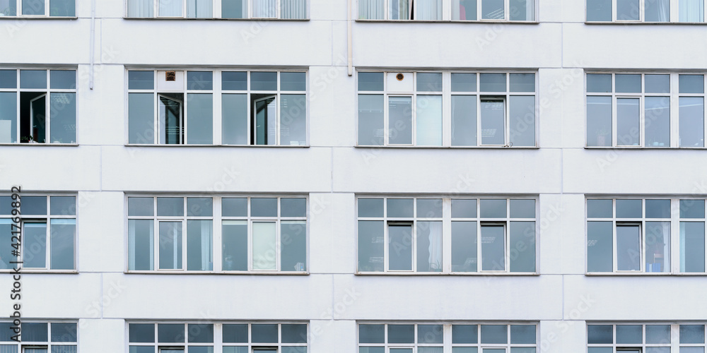 city building wall with large windows reflecting sunlight