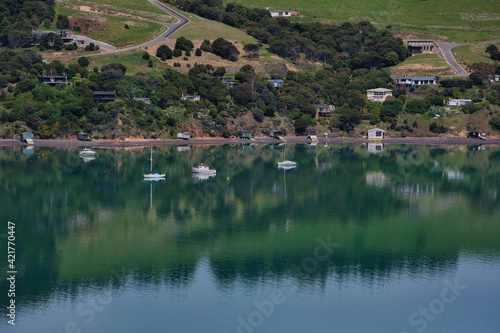 yachts on green lake with hill in the background