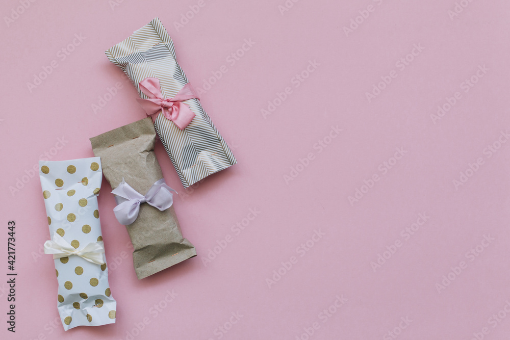 Many of DIY gift boxes on a pink background, not very neat gifts, but made with love Many of DIY gift boxes on a pink background, not very neat gifts, but made with love
