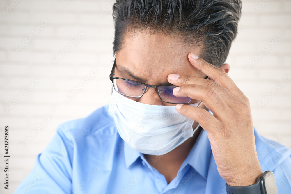 A young asian man with protective mask in face feeling sad A young asian man with protective mask in face feeling sad