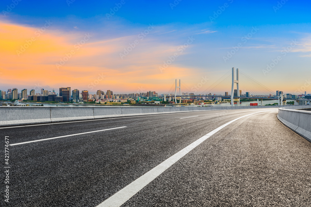 Asphalt highway and city skyline with bridge at dusk in Shanghai,China.