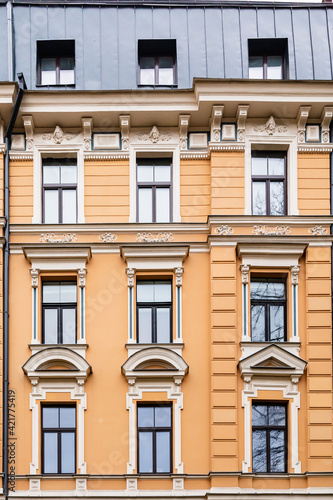 Orange brick art nouveau building façade with nine cream windows in Riga, Latvia, Europe