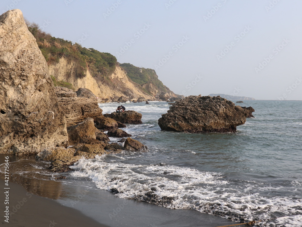 beautiful coastline with wave and stones under the sunset design for holiday and relaxation lifestyle