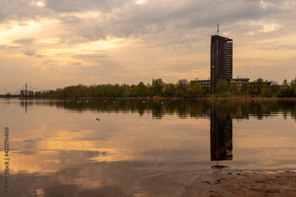 Naklejka premium Dark sunset view to TV building tower at Zakusala, Riga Latvia when sunset, island, tower and bridge are reflecting in river Daugava