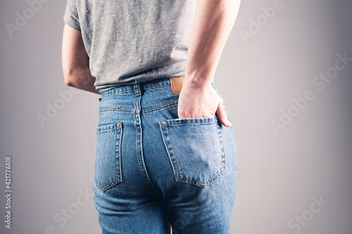 Fototapeta Naklejka Na Ścianę i Meble -  young woman in jeans close-up shot with hands in pocket