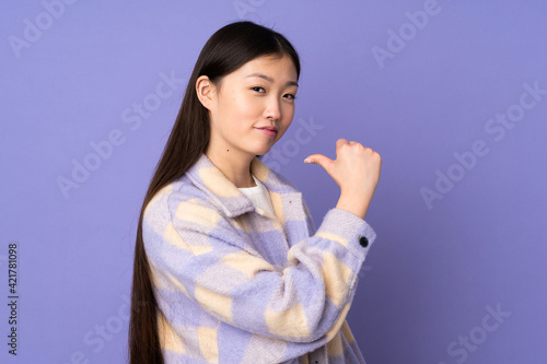 Young asian woman isolated on purple background proud and self-satisfied