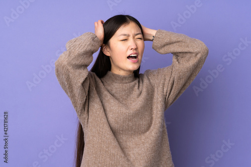 Young asian woman isolated on purple background stressed overwhelmed