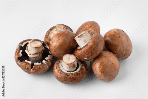 Fresh mushrooms on a light background. Brown champignons. Bunch of mushrooms.