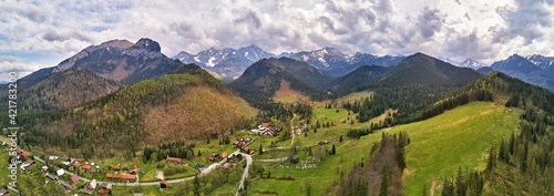 Spring rainy weather mountain panorama. Village in green forest hills. Road from Poland to Slovakia