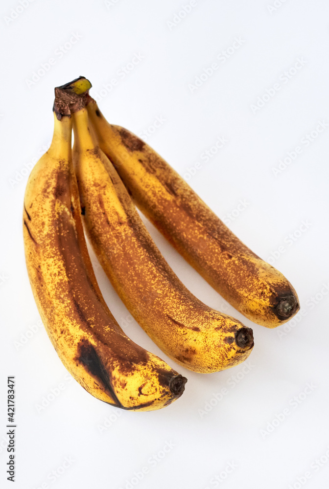 Overripe bananas in brown spots on a white background. StockFoto