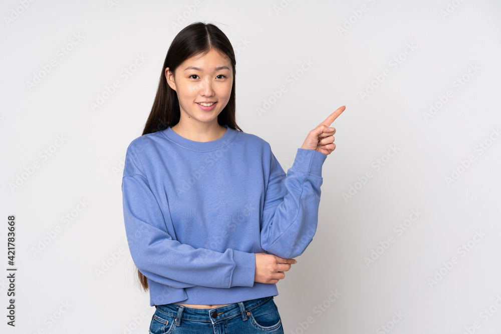 Young asian woman isolated on background happy and pointing up Young asian woman isolated on background happy and pointing up