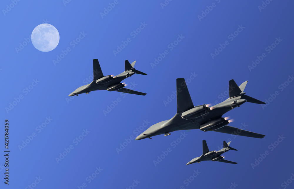 Three military fighter planes with exhaust flames during a surveillance flight in a blue clear night sky with moon and copy space Three military fighter planes with exhaust flames during a surveillance flight in a blue clear night sky with moon and copy space