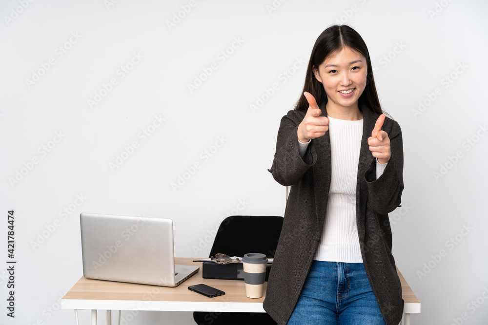 Business asian woman in her workplace isolated on white background pointing to the front and smiling Business asian woman in her workplace isolated on white background pointing to the front and smiling