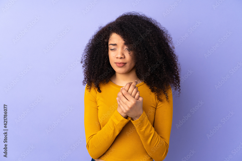 Young african american woman isolated on purple background suffering from pain in hands Young african american woman isolated on purple background suffering from pain in hands