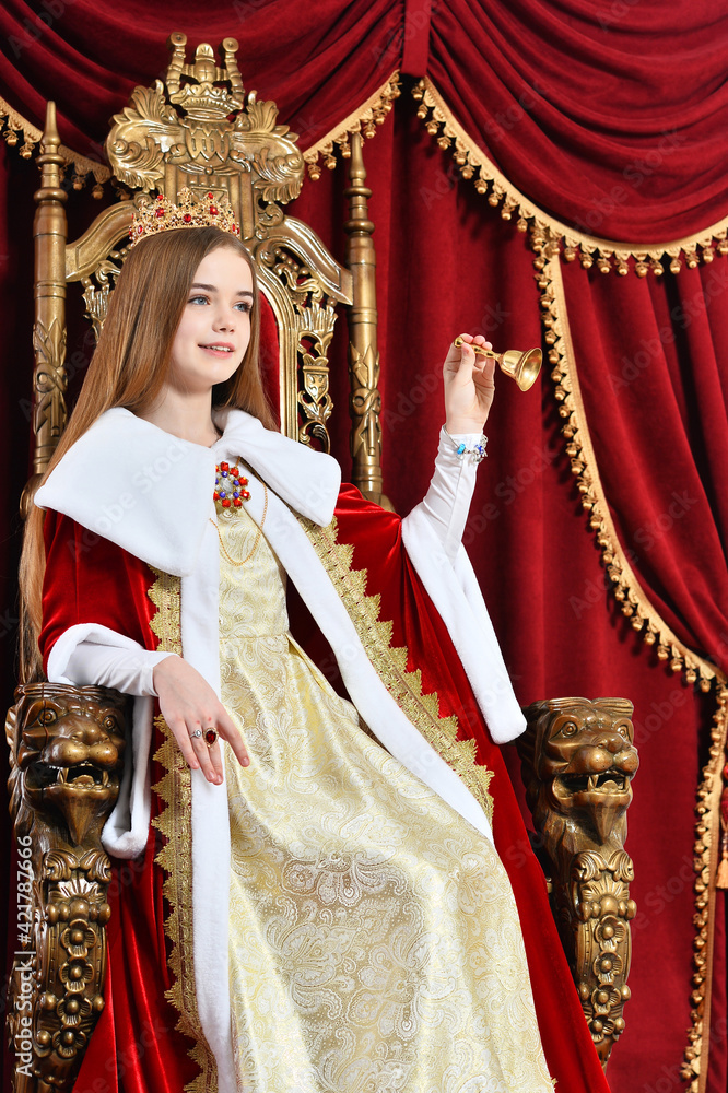 Portrait of beautiful princess with crown holding hand bell