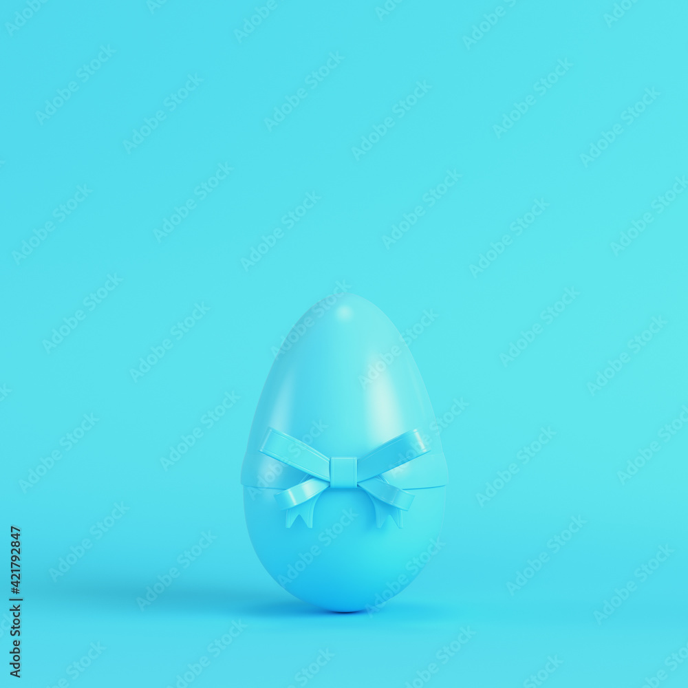 Easter egg with bow on bright blue background in pastel colors Easter egg with bow on bright blue background in pastel colors