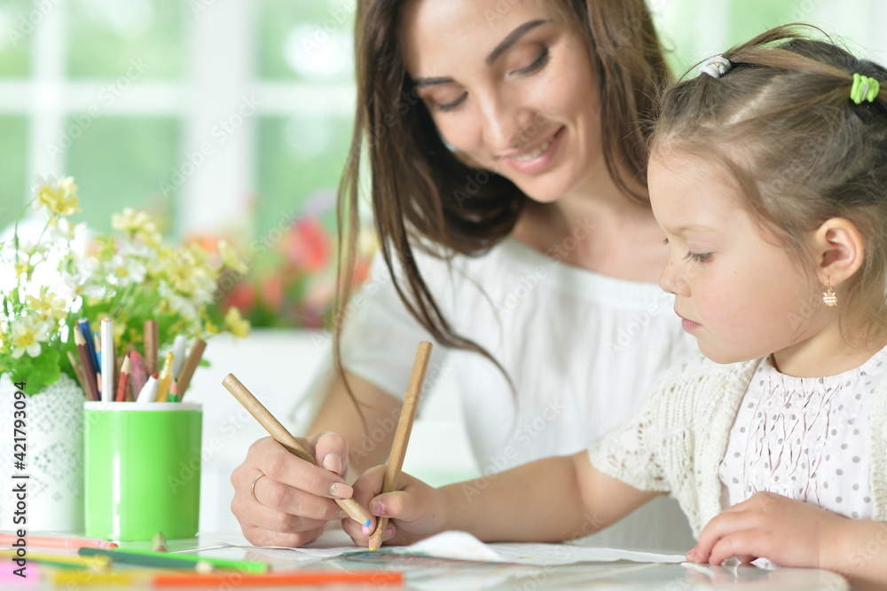 cute girl with mother drawing at the table cute girl with mother drawing at the table