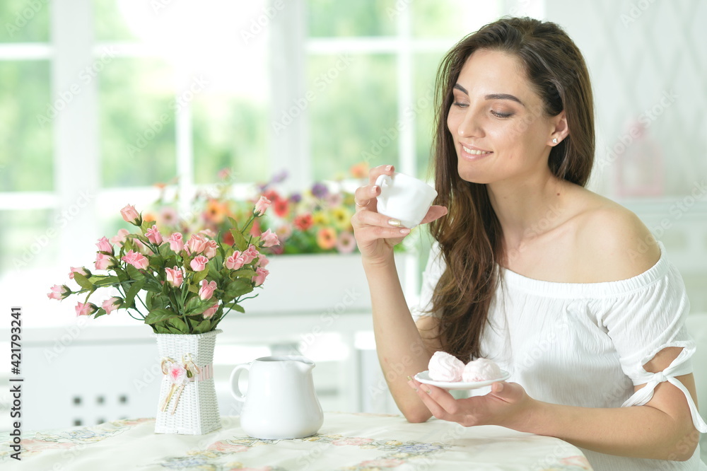 young beautiful woman holding white cup at home